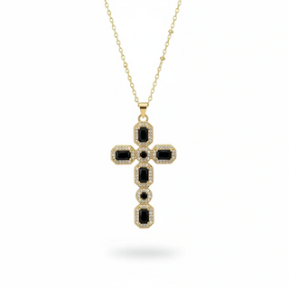 Gold necklace with a black cross pendant on a white background