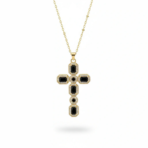 Gold necklace with a black cross pendant on a white background